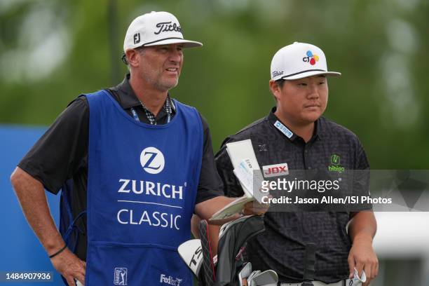 Sungjae Im of Korea goes over notes with his caddy before teeing off from the 9th tee during the Final Round of the Zurich Classic of New Orleans at...
