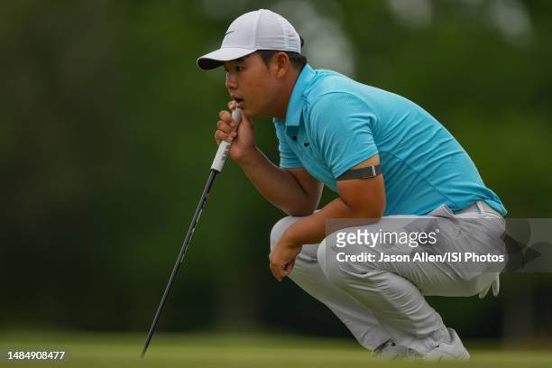 Tom Kim of of Korea checks his line before putting on the 18th green during the Final Round of the Zurich Classic of New Orleans at TPC Louisiana on...