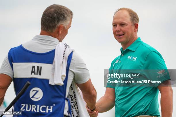 Dauffe of South Africa shakes hands with a caddy on the 18th green during the Final Round of the Zurich Classic of New Orleans at TPC Louisiana on...