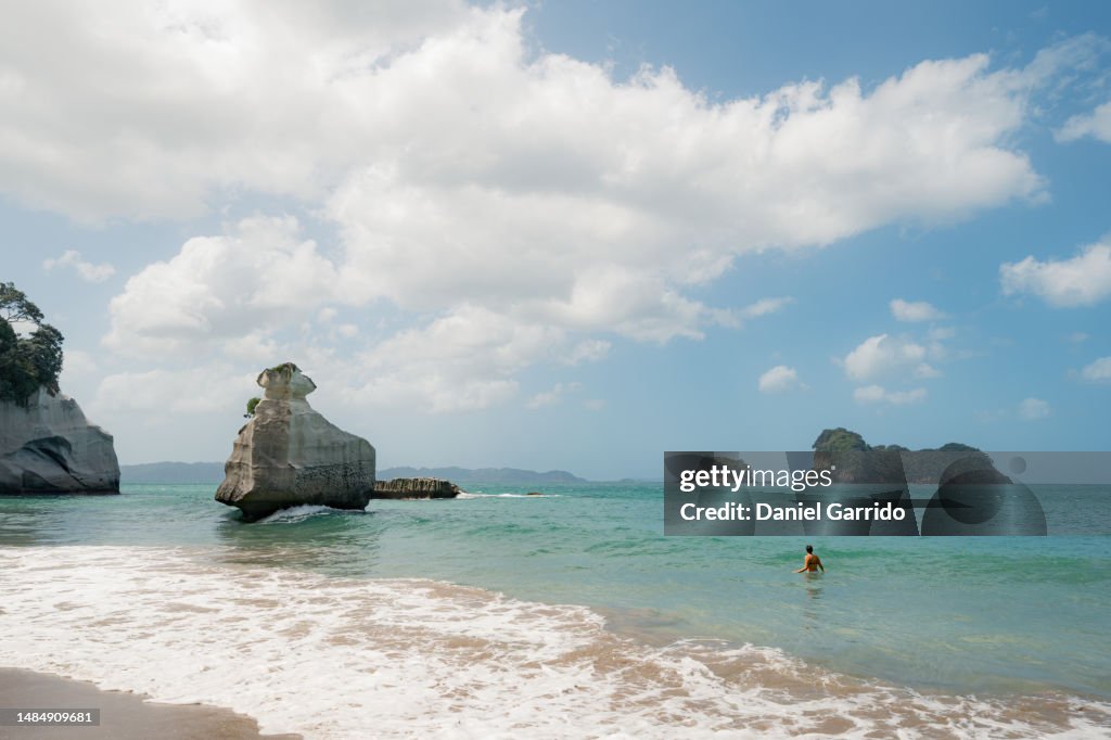 Unwinding in nature's bathtub, A woman enjoys a dip in the stunning Cathedral Cove