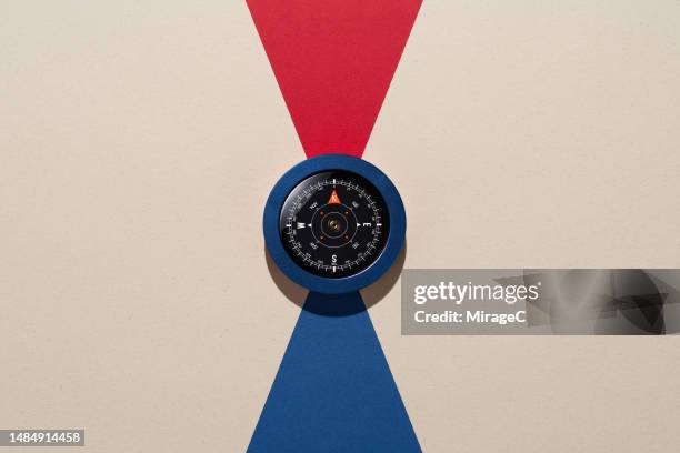 navigational compass pointing to red north and blue south - foco conceito imagens e fotografias de stock