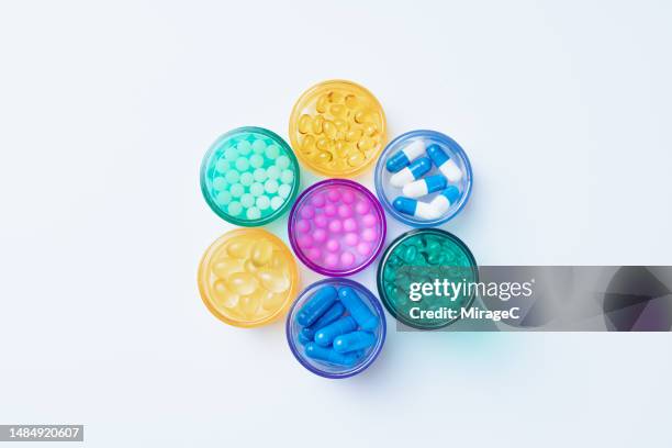 multi colored pill bottles containing a variety of medicine - generiek geneesmiddel stockfoto's en -beelden