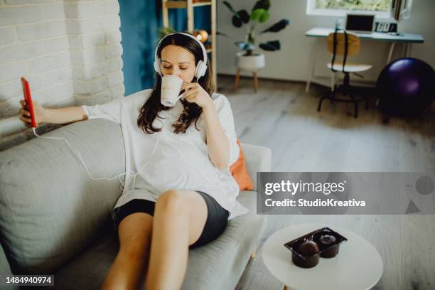 young pregnant woman relaxing with music and a smartphone - pregnant coffee 個照片及圖片檔