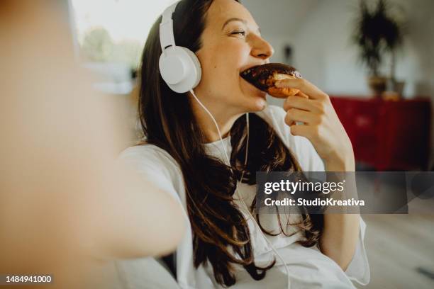 making a selfie while eating a doughnut - snap chocolate stock pictures, royalty-free photos & images