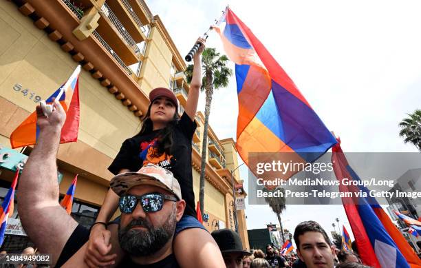 Los Angeles, CA Shaunt Kazanjian holds his daughter Melanie on his shoulders as they wave flags during the Armenian Genocide Commemorative Rally for...