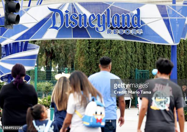 People walk toward an entrance to Disneyland on April 24, 2023 in Anaheim, California. Disney will lay off several thousand workers this week amid an...