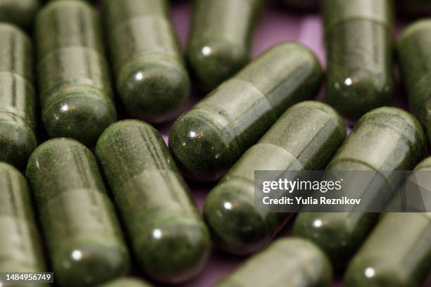 close-up of spirulina and chlorella pills - spirulinabacterie stockfoto's en -beelden