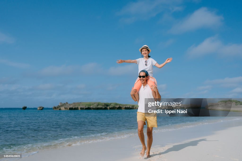 Father Giving Daughter Shoulder Ride On Beach High-Res Stock Photo ...