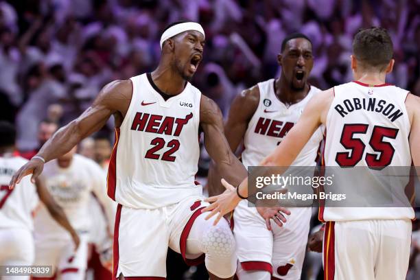 Jimmy Butler, Bam Adebayo and Duncan Robinson of the Miami Heat celebrate during the fourth quarter against the Milwaukee Bucks in Game Four of the...