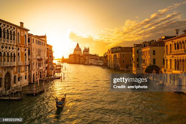 sunrise over the canale grande in venice with single gondola - gondola traditional boat stockfoto's en -beelden