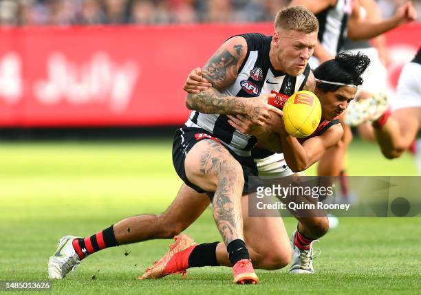 Jordan De Goey of the Magpies is tackled by Alwyn Davey Jnr of the Bombers during the round six AFL match between Collingwood Magpies and Essendon...