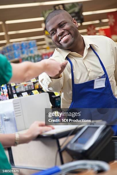 lebensmittelgeschäft clerk ausführender veränderungen zurück zum kunden beim check-out - cash back stock-fotos und bilder