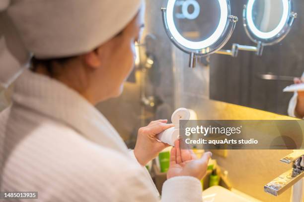 クリームを絞る女性 彼女の手にクリームチューブ - creme tube ストックフォトと画像