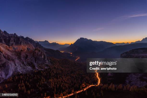 light trail through mountain valley - blue hour imagens e fotografias de stock