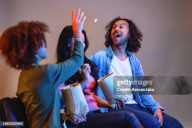 father catching popcorn with his mouth while watching a movie - catching food stock pictures, royalty-free photos & images