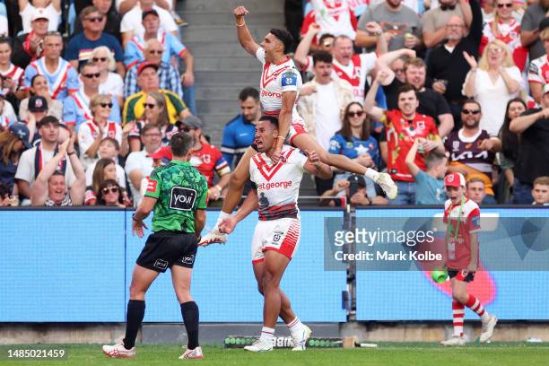 Tautau Moga of the Dragons celebrates with team mates after scoring a try during the round eight NRL match between Sydney Roosters and St George...