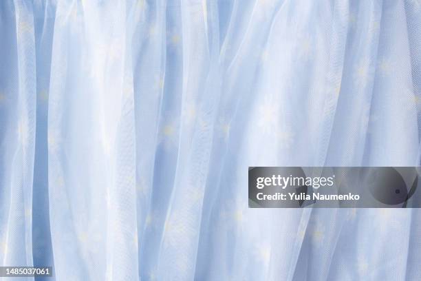 flowered fabric. sheer blue net-like tulle. the mesh fabric is folded in waves. white-blue veil or muslin. - organdy stockfoto's en -beelden