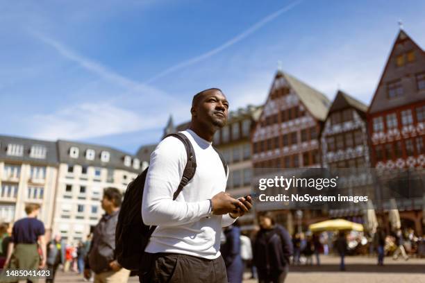 exploring romer square in frankfurt: casual black tourist ventures into romer square - frankfurt oder stock pictures, royalty-free photos & images