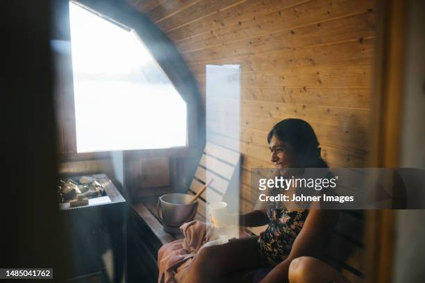 smiling woman relaxing inn sauna - sauna ストックフォトと画像