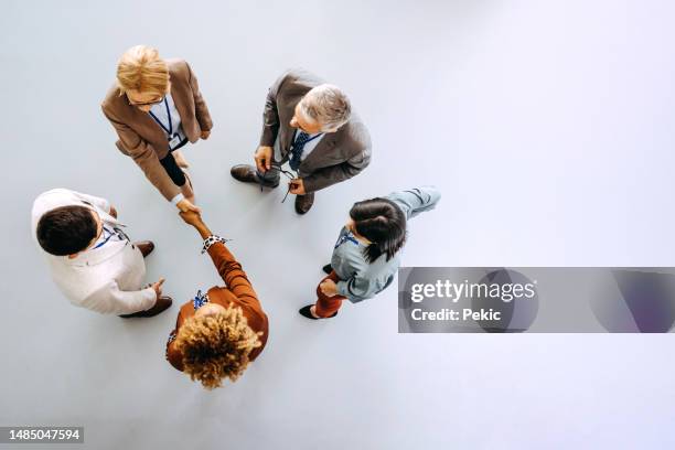 partenaires commerciaux se serrant la main au bureau - face à face photos et images de collection