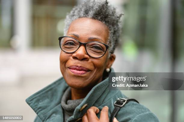 カメラを見ている街の通りで年配の成人黒人女性のポートレート - happy glasses ストックフォトと画像