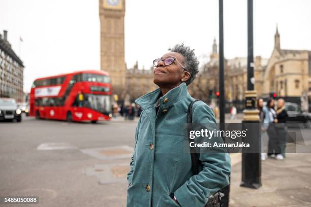 ältere erwachsene schwarze touristin, die london während ihrer solo-reise bewundert - places to visit stock-fotos und bilder