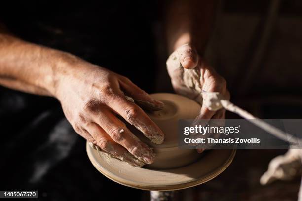 skilled wet hands of potter shaping the clay on potter wheel. - clay foto e immagini stock