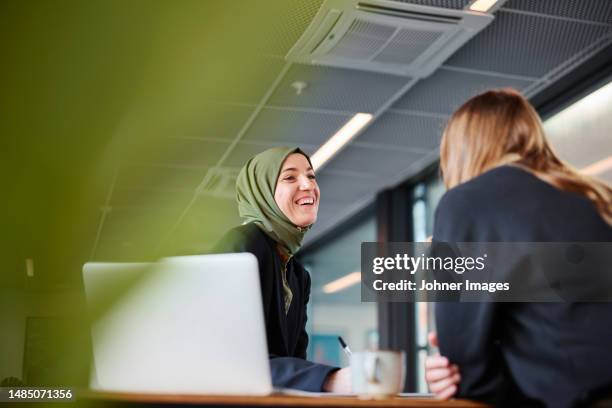 women sitting together in office - arab lifestyle stockfoto's en -beelden