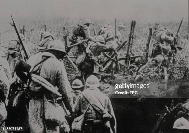 Infantry of the French Second Army wearing Adrian M15 steel helmets and carrying Lebel Model 1886 rifles advance out of their trench and through the...