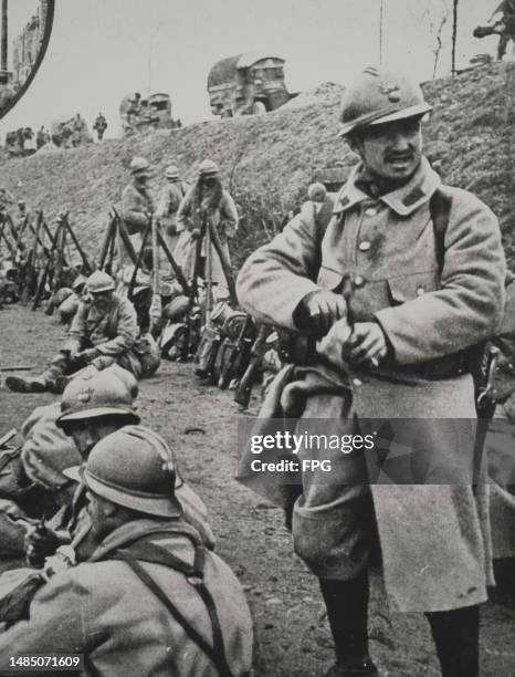 Infantry of the French Second Army wearing Adrian M15 steel helmets stack their Lebel Model 1886 rifles while in bivouac on the road between...