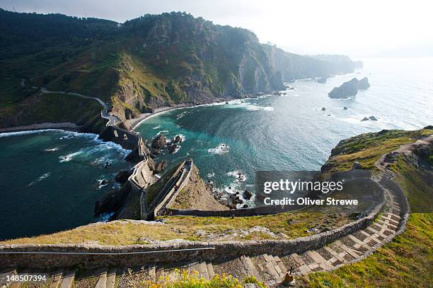 walkway to island of san juan de gaztelugatxe from hilltop of island. - spanish basque country stock pictures, royalty-free photos & images