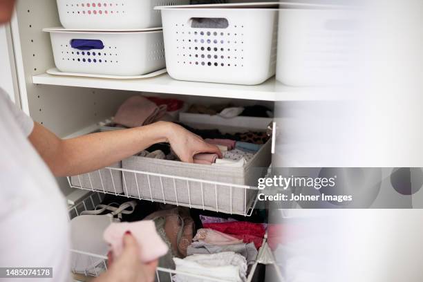 woman's hands putting clothes into basket - tidy room stock pictures, royalty-free photos & images