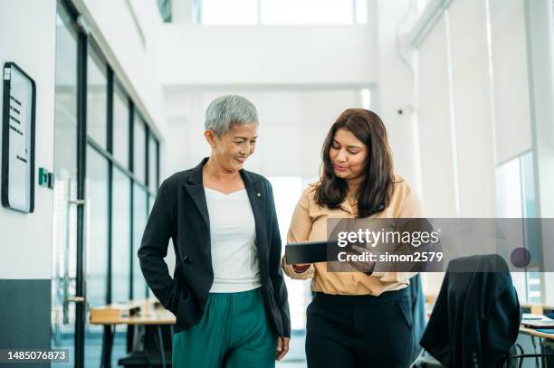 breaking barriers: women of different backgrounds join forces in modern office - indian office stock pictures, royalty-free photos & images