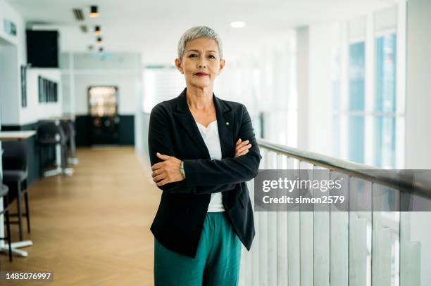 maturity and confidence: a middle-aged asian woman at the top of her game - arms crossed stock pictures, royalty-free photos & images