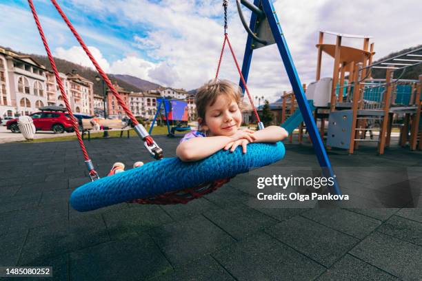 child is lying on a swing - altalena foto e immagini stock