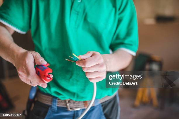 nicht wiederzuerkennender elektriker bereitet sich darauf vor, kabel in einer wohnung zu installieren - installationskunst stock-fotos und bilder