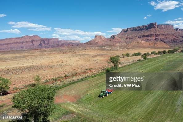 Aerial view of a rancher baling hay in an alfalfa field on a ranch in the desert near Moab, Utah