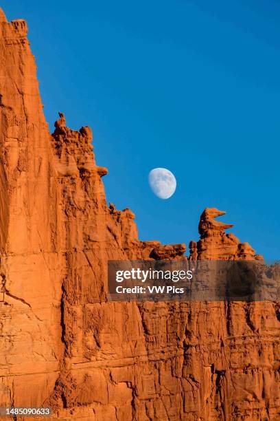 Rising moon between the Saddle and Pac Man in the Fisher Towers, eroded Cutler sandstone rock formations near Moab, Utah.