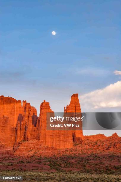 Rising moon over the Cottontail & the Titan in the Fisher Towers, eroded Cutler sandstone rock formations near Moab, Utah.