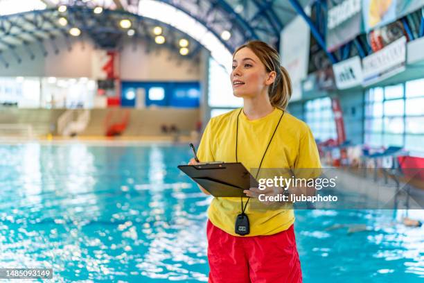 female swimming coach with a stopwatch and clipboard. - lifeguard stock pictures, royalty-free photos & images