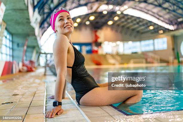 sportlich fit frau entspannen am pool rand - bademütze stock-fotos und bilder