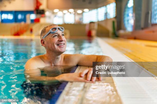 hombre maduro disfrutando de un día soleado en la piscina cubierta - nadador fotografías e imágenes de stock