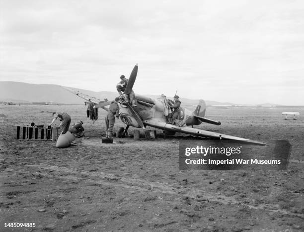 Ground crew of No 3203 Servicing Commando at work on Supermarine Spitfire Mark VB, EP286, repairing its undercarriage after failing on landing at...