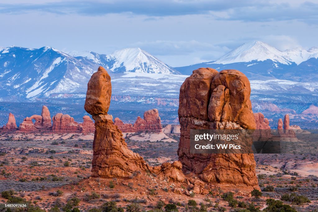Post-sunset view of Balanced Rock and the snow-capped La Sal Mountains. Arches National Park, Moab, Utah