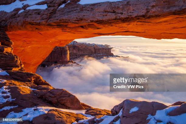 Sea of clouds below Mesa Arch at sunrise in winter in the Island in the Sky District of Canyonlands National Park, Utah.