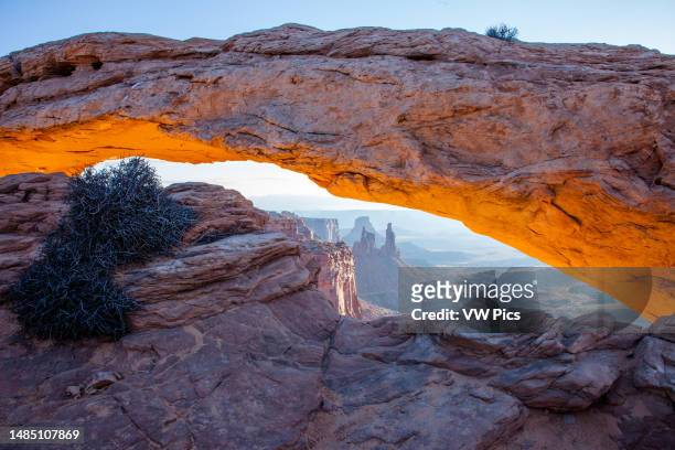 Mesa Arch at sunrise with the Washer Woman Arch, Monster Tower & Airport Tower. Canyonlands National Park, Utah.