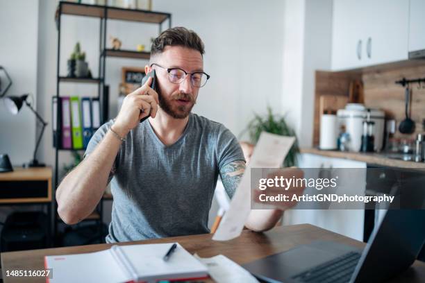 man paying his bills from home. - save our future babies stock pictures, royalty-free photos & images