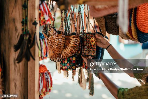 woman looking at souvenirs at a market stall - souvenir foto e immagini stock