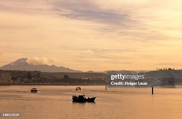 fishing boat and ms europa at sunset. - puerto montt stock pictures, royalty-free photos & images