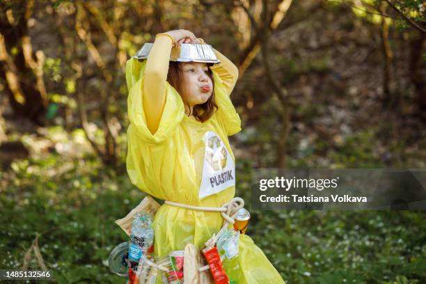 female child holding hands above head and grimacing playing dress-up using plastic garbage - trash bag dress stock pictures, royalty-free photos & images